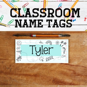 Puede incluir: Una etiqueta de nombre de clase azul y blanca con el nombre "Tyler" impreso en negro. La etiqueta tiene un fondo blanco con l&iacute;neas azules y una variedad de garabatos negros y blancos.