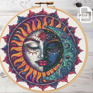 Può includere: Un motivo a punto croce colorato che presenta un sole e una luna con gli occhi chiusi e dettagli intricati. Il sole è giallo, arancione e rosso, mentre la luna è blu, verde e viola. Il motivo è circondato da un design a forma di mandala.