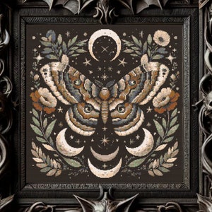 May include: A cross-stitch embroidery design featuring a moth with intricate wings, surrounded by crescent moons, stars, and floral elements. The design is set against a dark background.