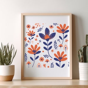 May include: A framed print with a white background and a colorful floral pattern. The flowers are in shades of orange, red, and blue. The print is in a wooden frame.