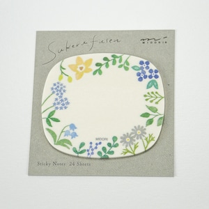Può includere: Un pacchetto di 24 note adesive con un design floreale con fiori gialli, blu e verdi. Le note hanno una forma ovale e uno sfondo bianco. Il testo "Sticky Notes 24 Sheets" è stampato sulla parte anteriore del pacchetto.