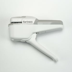 May include: A white stapler with a grey handle. The stapler is labelled "Harinacs Staple-Less Stapler".