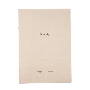以下が含まれることがあります： 表紙に「Weekly」と印刷されたベージュのノート。ノートは、機器を製造する会社であるLaconicによって作られています。