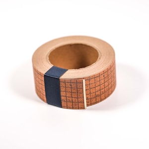 May include: A roll of decorative tape with a grid pattern in shades of brown and black. A dark blue band wraps around the tape. The tape is on a white background.
