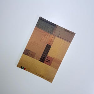 May include: A rectangular card with a vintage design featuring a mix of brown, tan, and olive green geometric shapes. The card has text that reads "B.O. CLASSIKY" and "8". The bottom edge has a series of colored stripes.