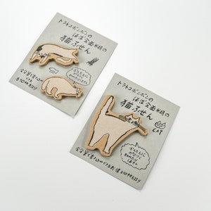 May include: Two sets of cat-shaped sticky notes with Japanese text. The text reads "Tra-neko Bonbon's Almost Entirely Rice Paper Cat Sticky Notes". The sticky notes are brown and feature illustrations of cats in various poses.