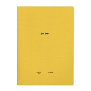 May include: A yellow notebook with the text "To Do" printed in black on the front cover. The notebook is labeled "LACONIC® 110 EQUIPMENT" in the bottom right corner.