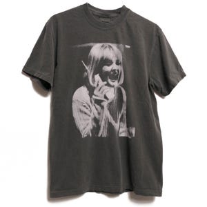 Puede incluir: Una camiseta gris oscuro con una impresión blanca de una mujer al teléfono, con el texto "Shroom Queens" en la parte inferior.