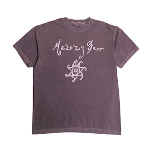 以下が含まれることがあります： 胸元にライトパープルの筆記体で「Mazzy Star」という文字がプリントされた、ダークパープルの半袖Tシャツ。文字の下には、中央が渦巻き状で6本の曲線的な光線を持つ、ライトパープルの太陽のグラフィックが描かれています。