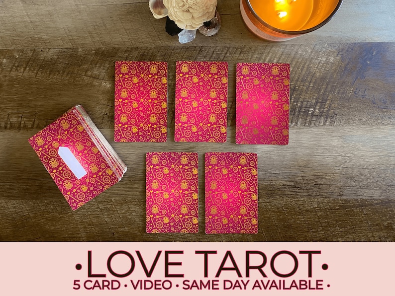 May include: Five pink tarot cards with gold designs, laid out on a wooden surface. The cards feature a variety of symbols, including hearts, keys, and crowns. The text "LOVE TAROT" is displayed below the cards, along with the text "5 CARD - VIDEO - SAME DAY AVAILABLE".