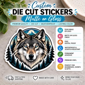 May include: A custom die cut sticker featuring a wolf head illustration centered in a circular frame with a forest and mountain background. The text reads Custom Die Cut Stickers Matte or Gloss, Premium Quality, Die-Cut, Weatherproof, Lasting Color.