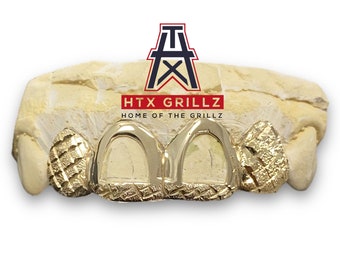 Puede incluir: Grillz de oro con un patrón de diamante en los dientes delanteros. Los grillz están colocados en un molde de boca. El texto "HTX GRILLZ HOME OF THE GRILLZ" es visible sobre los grillz.