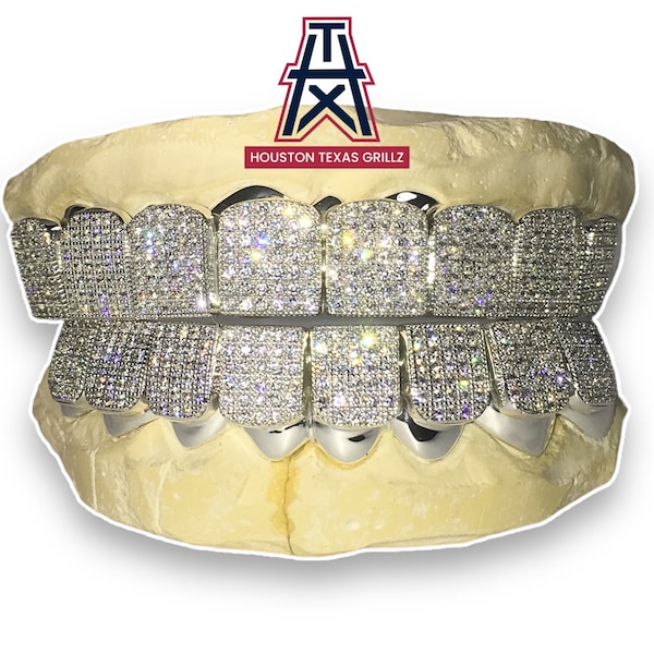 May include: A set of gold grillz with a diamond pattern. The grillz are set in a mold of a mouth. The text "HOUSTON TEXAS GRILLZ" is above the grillz.
