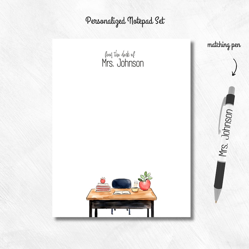 May include: Personalized notepad set with the text "from the desk of Mrs. Johnson." The notepad features a watercolor illustration of a desk with books, an apple, and a pen. A matching pen is included.