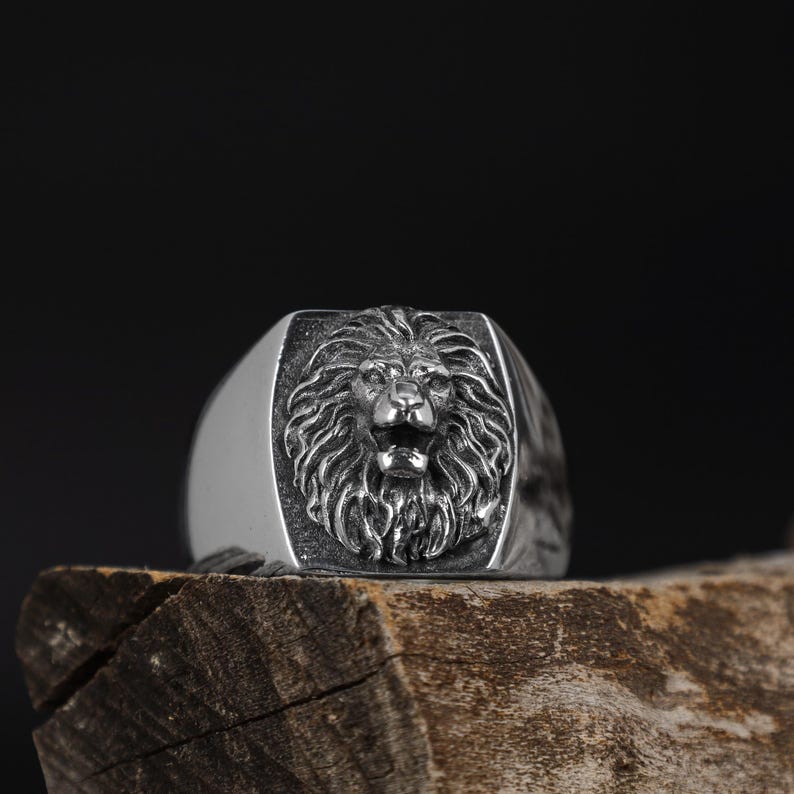African lion ring, safari inspired lion jewelry, symbolic king of the jungle statement band, and handcrafted bold accessory designed for those who are drawn to strength, courage, and untamed masculine energy. This striking ring features a detailed African lion head motif with textured mane engravings and powerful facial details, creating a commanding appearance inspired by wildlife symbolism, tribal aesthetics, and fearless leadership.