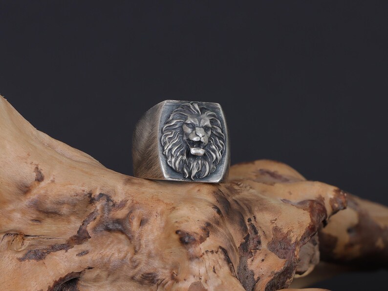 African lion ring, safari inspired lion jewelry, symbolic king of the jungle statement band, and handcrafted bold accessory designed for those who are drawn to strength, courage, and untamed masculine energy. This striking ring features a detailed African lion head motif with textured mane engravings and powerful facial details, creating a commanding appearance inspired by wildlife symbolism, tribal aesthetics, and fearless leadership.