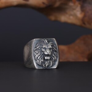 African lion ring, safari inspired lion jewelry, symbolic king of the jungle statement band, and handcrafted bold accessory designed for those who are drawn to strength, courage, and untamed masculine energy. This striking ring features a detailed African lion head motif with textured mane engravings and powerful facial details, creating a commanding appearance inspired by wildlife symbolism, tribal aesthetics, and fearless leadership.