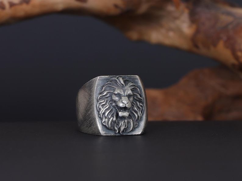 African lion ring, safari inspired lion jewelry, symbolic king of the jungle statement band, and handcrafted bold accessory designed for those who are drawn to strength, courage, and untamed masculine energy. This striking ring features a detailed African lion head motif with textured mane engravings and powerful facial details, creating a commanding appearance inspired by wildlife symbolism, tribal aesthetics, and fearless leadership.