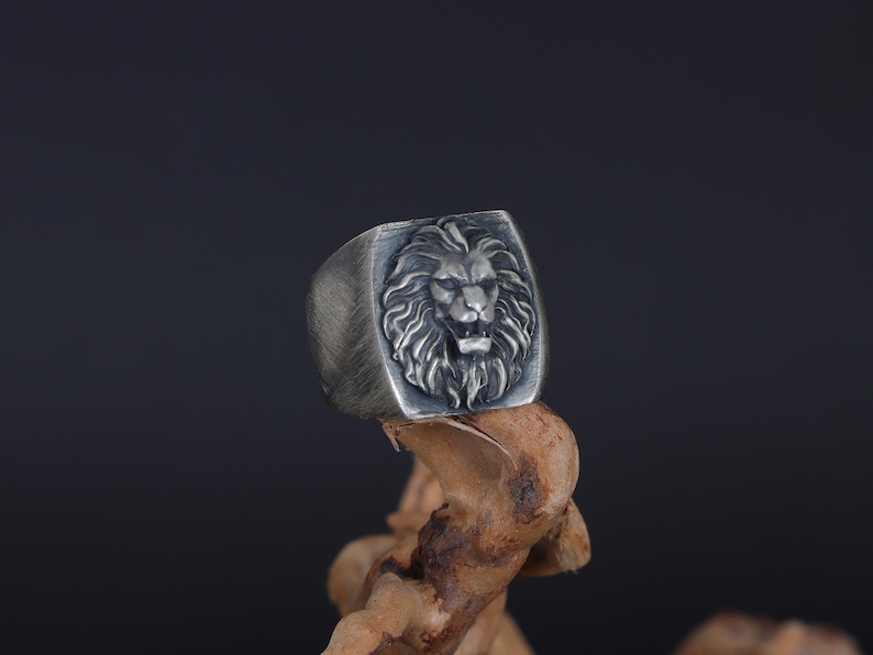African lion ring, safari inspired lion jewelry, symbolic king of the jungle statement band, and handcrafted bold accessory designed for those who are drawn to strength, courage, and untamed masculine energy. This striking ring features a detailed African lion head motif with textured mane engravings and powerful facial details, creating a commanding appearance inspired by wildlife symbolism, tribal aesthetics, and fearless leadership.