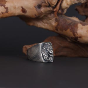 African lion ring, safari inspired lion jewelry, symbolic king of the jungle statement band, and handcrafted bold accessory designed for those who are drawn to strength, courage, and untamed masculine energy. This striking ring features a detailed African lion head motif with textured mane engravings and powerful facial details, creating a commanding appearance inspired by wildlife symbolism, tribal aesthetics, and fearless leadership.
