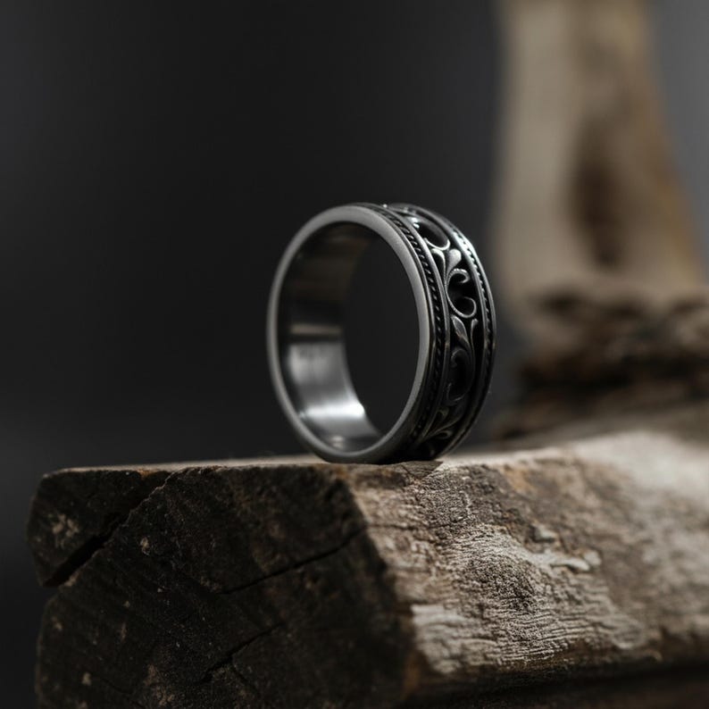Puede incluir: Un anillo plateado con un intrincado dise&ntilde;o floral. El anillo es de metal y tiene un acabado pulido. El dise&ntilde;o presenta un patr&oacute;n repetitivo de hojas y vides arremolinadas. El anillo es de estilo banda, adecuado para el uso diario. Di&aacute;metro: aproximadamente 2 cm.
