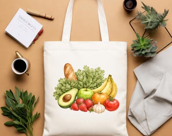 May include: A white tote bag featuring a watercolor illustration of fresh produce. The image includes a loaf of bread, green leafy vegetables, bananas, an avocado, an apple, strawberries, a tomato, a garlic bulb, and an orange.