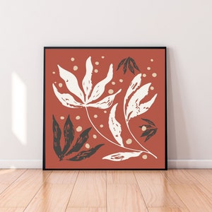 Może przedstawiać: Cyfrowy wydruk artystyczny przedstawiający stylizowany wzór kwiatowy z białymi liśćmi i czarnymi łodygami na tle terakoty. Wydruk ma minimalistyczny charakter i świetnie będzie wyglądał w nowoczesnym domu.