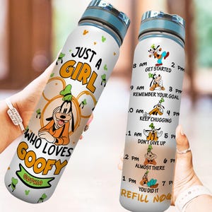 May include: White water bottle with a yellow and green design featuring a cartoon character. The bottle has a blue lid and a motivational quote that says "Just a girl who loves Goofy". The bottle also has a time schedule with a cartoon character for each hour.