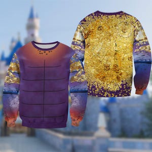 Puede incluir: Una sudadera de manga larga con un dise&ntilde;o &uacute;nico. La parte delantera muestra un torso morado con l&iacute;neas negras, que pasa a naranja en la parte superior. Las mangas muestran un patr&oacute;n dorado y azul. La parte trasera de la sudadera tiene un dise&ntilde;o dorado y morado.