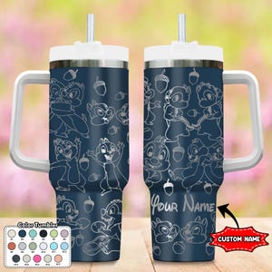May include: A blue stainless steel tumbler with a white handle and lid. The tumbler features a white outline design of chipmunks and acorns. The tumbler has a space for a custom name, "Your Name".