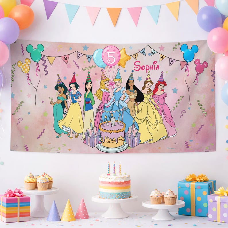 May include: A rectangular birthday banner featuring a pink watercolor background with illustrations of eight Disney princesses, a tiered cake, and the text '5' and 'Sophia'. The banner is decorated with colorful balloons, stars, and streamers.