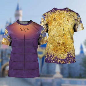 Puede incluir: Dos camisetas de manga corta. Una camiseta tiene un torso morado con una parte superior naranja degradada y una serie de l&iacute;neas negras. La otra camiseta tiene un patr&oacute;n dorado y amarillo con un borde morado. Ambas camisetas tienen cuello y mangas moradas.