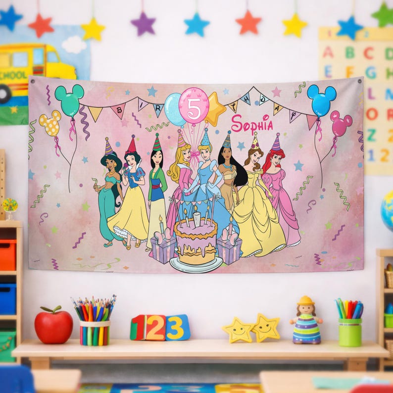 May include: A rectangular pink birthday banner featuring illustrations of eight Disney princesses wearing party hats, a central birthday cake with candles, balloons, and the text "BIRTHDAY" and "Sophia" printed in a decorative font.