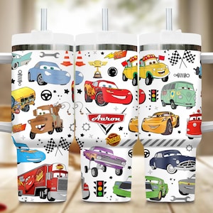 May include: White tumbler featuring a colorful cartoon car design. The design includes various car characters, racing flags, and the name "Aaron". The tumbler has a white lid and a straw.