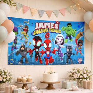 May include: A rectangular blue party banner featuring the text 'JAMES and his AMAZING FREINDS' and the number '6'. The banner displays cartoon characters including Spider-Man, Ghost-Spider, Hulk, and other figures against a city skyline background.