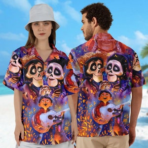 May include: A colorful Hawaiian shirt with a print of characters from the animated film Coco. The shirt features a purple, blue, and orange background with images of Miguel, Hector, and Dante.