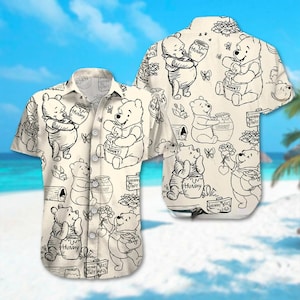 May include: A beige button-up shirt with a short sleeve design featuring a repeated pattern of Winnie the Pooh characters holding honey pots. The text "Hunny" and "Hunny Bees Only Here" is printed on the shirt.