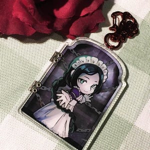 Può includere: Un ciondolo in acrilico trasparente con un'illustrazione a cartoni animati di una cameriera in un vestito bianco e un top viola. Il ciondolo ha una chiusura in metallo ed è decorato con catene. Una rosa rossa è sullo sfondo.