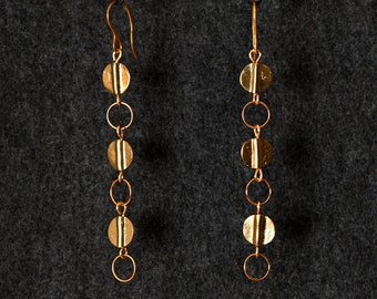 May include: A pair of gold dangle earrings with a chain of small round discs and a pearl at the top.