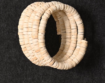 May include: A white beaded bracelet made of multiple strands of small, round beads. The bracelet is coiled into a circle.