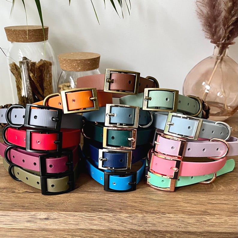 A collection of Biothane collars stacked on top of each other in a selection of colour choices. Shown in different colours of biothane and hardware, for you to design your own. All with a buckle, D-Ring. They have a soft leather appearance.