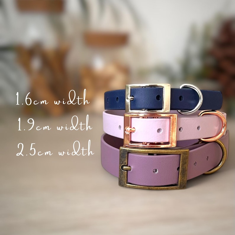 May include: Three stacked collars in navy blue, light pink, and mauve. The navy collar is 1.6cm wide with a silver buckle, the pink is 1.9cm wide with a rose gold buckle, and the mauve is 2.5cm wide with an antique brass buckle and D-ring.