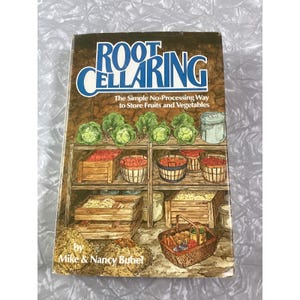 May include: A vintage book titled "Root Cellaring" with a detailed illustration of a root cellar. The cover features the text "Root Cellaring" in blue and white, with the subtitle "The Simple No-Processing Way to Store Fruits and Vegetables."