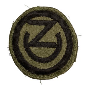 May include: A green and black military patch with a stylised letter "Z" inside a circle.
