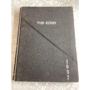 May include: A dark gray, textured hardcover book titled THE ECHO with the year 1937 printed in white on the front cover. A diagonal line divides the cover, separating the title from the year. The book has a rectangular shape and a worn spine.
