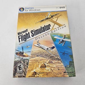 May include: A Microsoft Flight Simulator X Deluxe Edition PC DVD game case featuring a large gold X, a passenger jet, a seaplane, and a helicopter. The cover displays a desert landscape with pyramids, the Games for Windows logo, and an ESRB E rating.