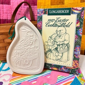 May include: White ceramic cookie mold shaped like a bunny holding a basket of eggs. The mold is part of a 1997 Longaberger Easter Cookie Mold limited edition set.
