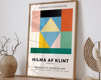 May include: A poster advertising a retrospective exhibition of Hilma af Klint's work at the Museum of Modern Art. The poster features a geometric abstract painting in shades of pink, yellow, blue, green, and orange. The text on the poster reads "Retrospective Exhibition", "Hilma af Klint", "De 1862 a 1944", "Museum of Modern Art", and "20 Juin - 25 Septembre 1974 Tous Les Jours".