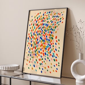 May include: A framed abstract art print featuring a pattern of colorful, oval shapes in shades of red, orange, yellow, green, blue, and pink against a cream background. The artwork is displayed in a black frame.