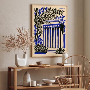 May include: A framed print with a blue and black illustration of a building with columns and a leafy tree. The print has the word "Athens" in the top right corner.